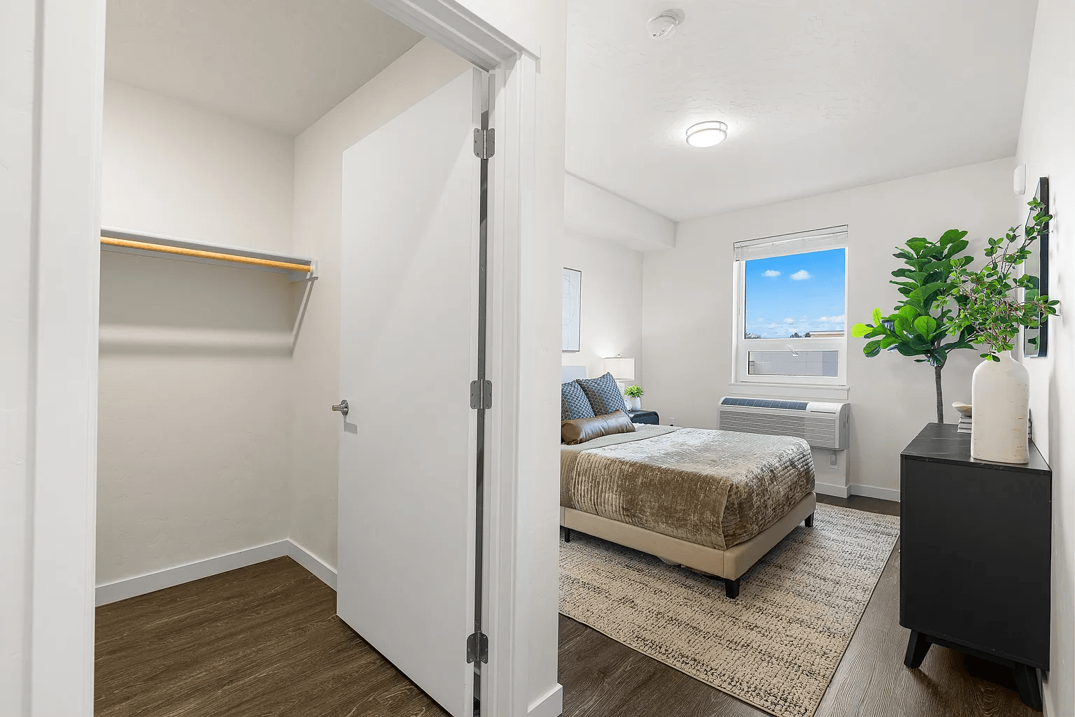 A bedroom with a bed, nightstand, and window.